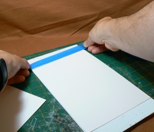Photograph of taping Bristol Board to the HO
 scale corrugate metal styrene sheet