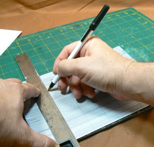 Photograph of marking Bristol Board using a
 ballpoint pen to make the HO scale metal roofing