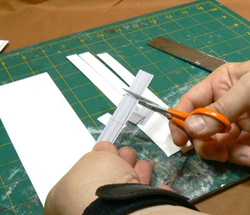 Photograph of cutting out strips of HO scale
 corrugated roofing