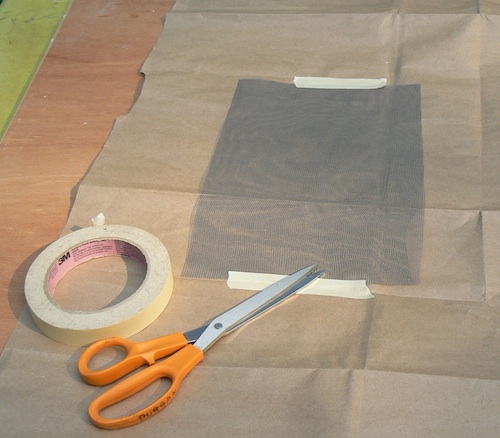 Photograph of 
screen being taped down for spraying